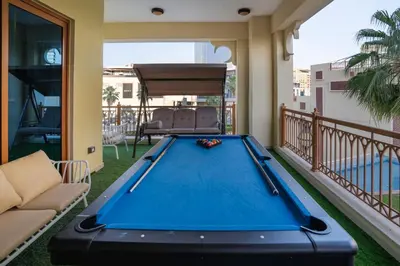 a pool table on the balcony of a house at PJ- Premium Palm Jumeirah Apartment - Beachfront, Pool & Balcony in Dubai