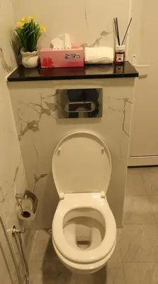 a white toilet in a bathroom with a counter at 1BHK Holiday Location in Dubai