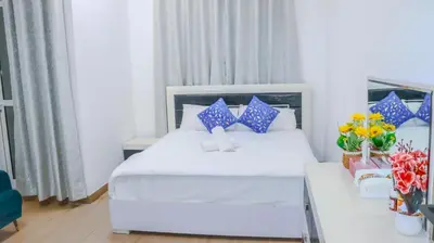 a hotel room with a bed and a table with flowers at 1BHK Holiday Location in Dubai