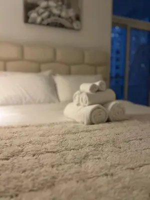 a pile of towels sitting on top of a bed at 5 Min Downtown in Dubai