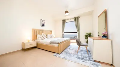 a bedroom with a bed and a desk and a window at Luxury Casa - Paramount Sea View Apartment 2BR in Dubai