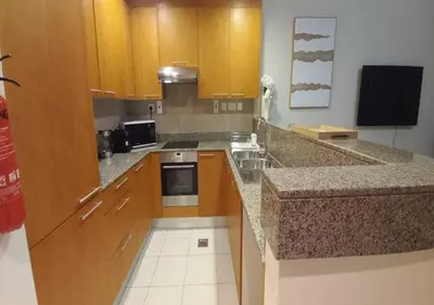 a kitchen with wooden cabinets and a counter top at Bay Square studio Bay view in Dubai