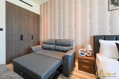 a bedroom with a bed and a chair next to a bed at New Studio In Arjan by Deleguest in Dubai