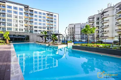 a large swimming pool in front of a building at Modern Studio in Arjan by Deleguest in Dubai