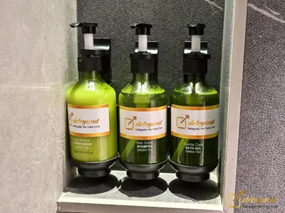 three bottles of green liquid sitting on a shelf at Modern Studio in Arjan by Deleguest in Dubai
