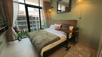 a bedroom with a bed with a mirror and a window at Relaxing Retreat in Meydan in Dubai