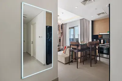 a mirror reflecting a kitchen and a living room at Lagoon Charm Luxurious Waterfront Living in Dubai