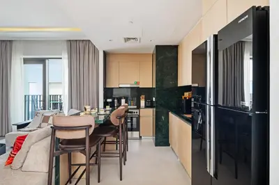 a kitchen and dining room with a black refrigerator at Lagoon Charm Luxurious Waterfront Living in Dubai