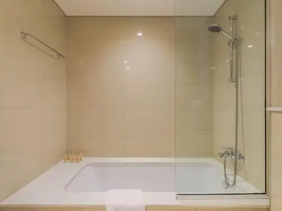 a bathroom with a tub with a glass shower at TRPS - Burj Royale, Downtown Dubai - 2BR - Burj Khalifa View - Furnished & Ready in Dubai