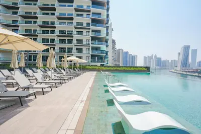 a swimming pool with lounge chairs and a large building at Stylish Retreat in Business Bay in Dubai