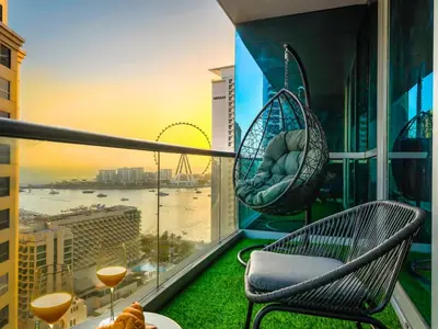 a balcony with two chairs and a table and drinks at WonderfulStay at Marine Towers - Full Ain & Marina View - JBR Grande Living - Brand New Apartments in Dubai