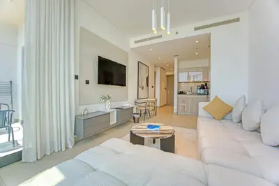 a living room with a white couch and a table at High-Floor Luxury Spacious 1BR in Sobha Waves in Dubai