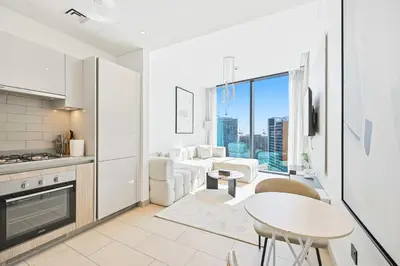 a kitchen and living room with a couch and a table at High-Floor Luxury Spacious 1BR in Sobha Waves in Dubai