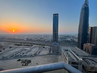 a view of a city with buildings and a sunset at Elegant 1 Bedroom Apartment, The Lofts West Tower, Downtown Dubai By Al sarya Holiday Homes in Dubai