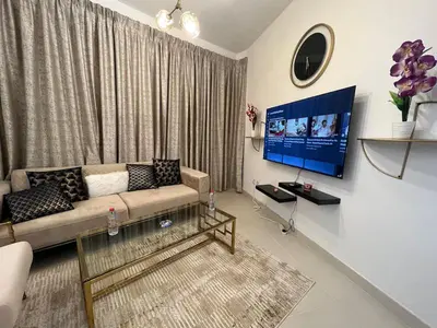 a living room with a couch and a flat screen tv at Elegant 1 Bedroom Apartment, The Lofts West Tower, Downtown Dubai By Al sarya Holiday Homes in Dubai