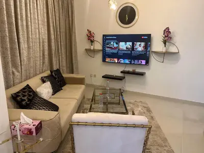 a living room with a couch and a tv at Elegant 1 Bedroom Apartment, The Lofts West Tower, Downtown Dubai By Al sarya Holiday Homes in Dubai