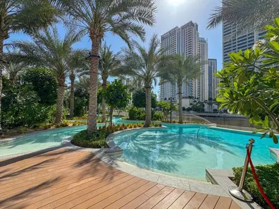 a swimming pool with palm trees in a city at Charming 1BR with Airy Terrace, Pool and Gym Access in Dubai