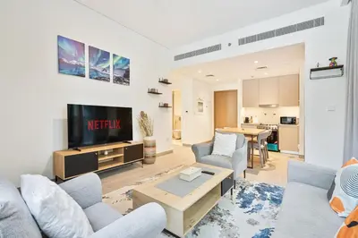 a living room with two couches and a tv at Charming 1BR with Airy Terrace, Pool and Gym Access in Dubai