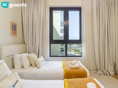 a hotel room with two beds and a window at HiGuests - Soothing Seaside 2 BR Haven in La Mer in Dubai