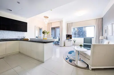 a kitchen and living room with a couch and a table at Damac Maison Mall Street! 2 Bedroom, 1-minute to Dubai Mall! in Dubai