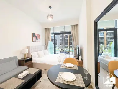 a living room with a couch and a table at Charming Studio with Balcony in Azizi Riviera in Dubai