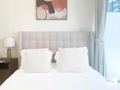 a bedroom with a white bed with white pillows at Charming Studio with Balcony in Azizi Riviera in Dubai