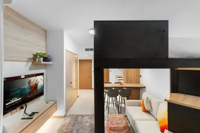 a loft bed in a living room with a tv at Miami Vibes | Canal View | Fully Furnished Studio in Dubai