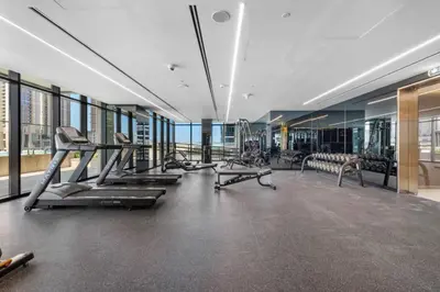 a gym with treadmills and machines in a building at Miami Vibes | Canal View | Fully Furnished Studio in Dubai
