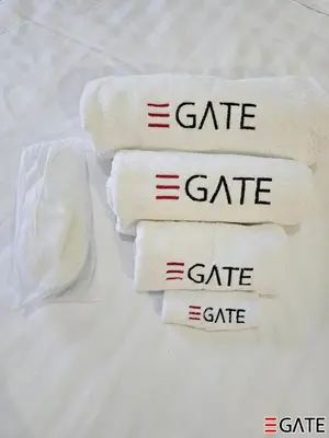 four towels with the word gate on them on a bed at EGATE - Studio - 10th Floor - Balcony with a View - 01-1014 in Dubai