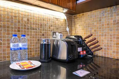 a kitchen counter with a toaster and water bottles at Luxe 2BR with Fountain Views and Walk-Around Terrace in Dubai