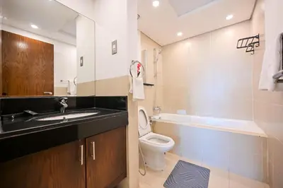 a bathroom with a sink and a toilet and a bath tub at Luxe 2BR with Fountain Views and Walk-Around Terrace in Dubai