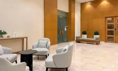 a lobby with chairs and a table in a building at Luxe 2BR with Fountain Views and Walk-Around Terrace in Dubai