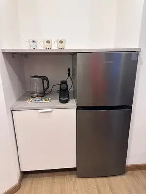 a kitchen with a black refrigerator and a counter at Cozy Studio Apartment in Dubai