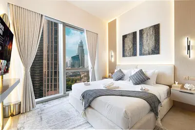 a bedroom with a large bed with a large window at Luxury Grande Suites by Hostiva - Full Burj Khalifa View in Dubai