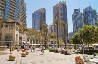 a group of people walking in a city with tall buildings at Luxury Casa - Marina Diamond 2 in Dubai