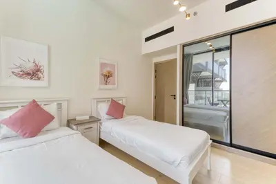 two beds in a room with a balcony at PVH - Cosy 2BR Plus Study - Binghatti Crescent in Dubai