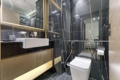 a bathroom with a toilet and a sink and a mirror at PVH - Cosy 2BR Plus Study - Binghatti Crescent in Dubai