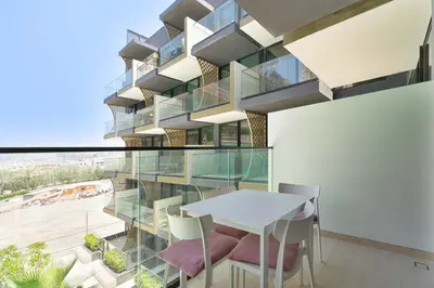 a glass building with a table and chairs at PVH - Cosy 2BR Plus Study - Binghatti Crescent in Dubai