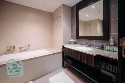 a bathroom with a sink and a large mirror at Steps to Beach - Resort Residence - Palm Jumeirah in Dubai