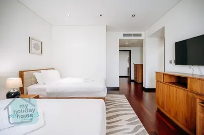 a hotel room with two beds and a flat screen tv at Steps to Beach - Resort Residence - Palm Jumeirah in Dubai