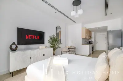 a living room with a tv and a white couch at LUX The Burj Khalifa Downtown View Studio 2 in Dubai