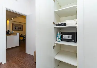 a room with a white closet with a microwave at 1BR Elegant Apartment in Marina Diamond 3 Metro Access in Dubai