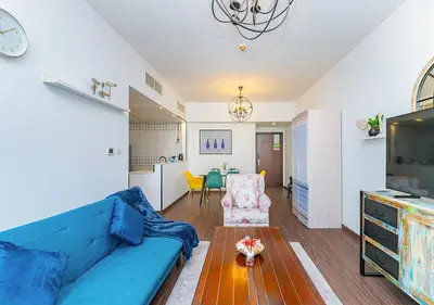 a living room with a blue couch and a table at 1BR Elegant Apartment in Marina Diamond 3 Metro Access in Dubai