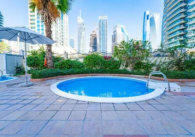 a swimming pool with a city skyline in the background at 1BR Elegant Apartment in Marina Diamond 3 Metro Access in Dubai