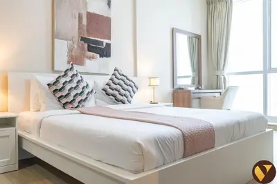 a white bedroom with a large white bed with pillows at Vogue Marina Torch Tower near JBR Beach and Dubai Marina Mall, Two Bedroom Apartment with Balcony and City Skyline View, Access to all Amenities in Dubai