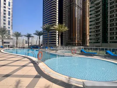 a large swimming pool in a city with tall buildings at Vogue Marina Torch Tower near JBR Beach and Dubai Marina Mall, Two Bedroom Apartment with Balcony and City Skyline View, Access to all Amenities in Dubai