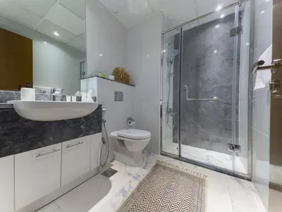 a bathroom with a shower and a sink and a toilet at Modern and Spacious 2BR in Business Bay in Dubai