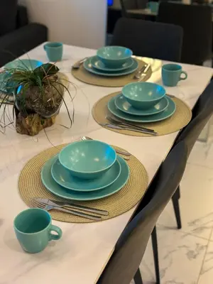 a table with blue plates and silverware on it at Modern and Spacious 2BR in Business Bay in Dubai
