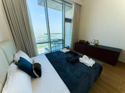 a hotel room with a bed with a large window at Modern and Spacious 2BR in Business Bay in Dubai