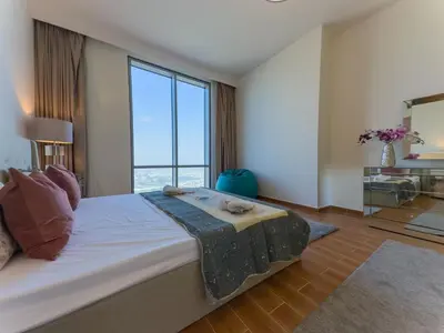 a bedroom with a large bed with a large window at Modern and Spacious 2BR in Business Bay in Dubai